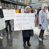 Une femme tient une pancarte qui dit "les Canadiens ont besoin de professionnels expérimentés comme nous. Laissez-nous travailler».
