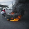 Des manifestants dressent une barricade avec un pneu en feu non loin d'une station d'essence à Port-au-Prince.