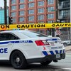Une voiture de police en plein centre-ville d’Halifax. Une section de la rue est fermée avec du ruban jaune.