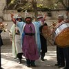 L'homme habillé de vêtements traditionnels afghans est entouré de musiciens.