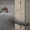 Un homme de dos tient la poignée de la porte d'une salle d'audience au palais de justice de Rimouski.