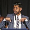 Hasan Minhaj, en complet, s'adresse à une foule. 