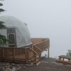Un géodôme dans un décor de brouillard.