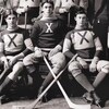 Photo en noir et blanc de cinq joueurs de hockey qui posent avec leur bâton à la main.