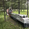 Un train en miniature transportant des personnes. 
