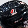 Gros plan sur un casque de hockey noir, avec le logo d'Hockey Canada