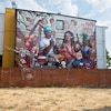 Une murale qui dépeint quatre personnes jouant de la musique et en arrière-plan des visages de personnalités connues de la communauté.