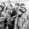 Des enfants derrière les barbelés d'un camp de concentration.