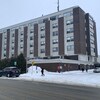 Des piétons marchent dans la neige devant l'Hôpital de Rouyn-Noranda.