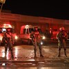 Des soldats se tiennent debout devant des ambulances à l'extérieur d'un centre de détention.