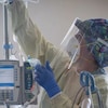 Une employée des services médicaux portant un masque N95 et une visière au travail dans un hôpital albertain.