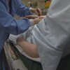 Une infirmière attache un bracelet à un patient.