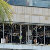 Des policiers se tiennent devant l'hôtel Shangri-La, dont les vitres ont toutes été détruites par l'impact de l'explosion.