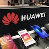 Des téléphones cellulaires vendus par SaskTel devant un présentoir portant le logo de Huawei.