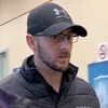 Casquette sur la tête, le jeune homme marche dans un corridor du palais de justice, avec son avocate.