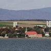 L'île d'Orléans vue de l'autre côté du fleuve, avec l'église Saint-Jean et ses fermes.