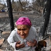 Une femme âgée devant sa maison détruite par l'incendie.