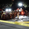 Des pompiers rassemblés dans une rue après un incendie.