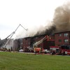 Un panache de fumée s'échappe du toit du bâtiment touché par l'incendie. 