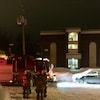 Des pompiers sont à l'extérieur d'un édifice à logements. 