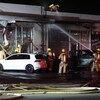 Des pompiers interviennent sur un immeuble endommagé par les flammes. 