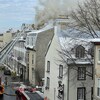 Un imposant panache de fûmée se dégage de la toiture d'un hôtel. Des pompiers sont sur place.