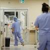 Des infirmiers marchent dans le couloir d'un hôpital.