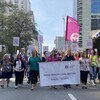 Des infirmières avec des pancartes en main et un mégaphone marchent sur la rue Burrard, à Vancouver, le mercredi 5 octobre 2022.