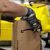 Un employé manipule une boîte dans un entrepôt d'Amazon.