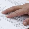 Une femme âgée consulte un dictionnaire.