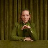 Maude Landry habillée en vert, dans une pièce verte, avec une grenouille.