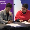 Deux femmes sont assises et signent un document, le 29 septembre 2023, à Iqaluit. 