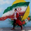 Une femme iranienne passe devant une fresque représentant le drapeau national iranien à Téhéran (archives).