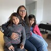 Portrait de la jeune famille assise sur un lit. 