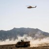 Un hélicoptère et deux chars d'assaut se déplacent dans le cadre d'un exercice militaire dans la ville d'Ispahan en Iran.