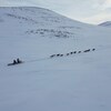 Deux personnes dans un traîneau tiré par une douzaine de chiens, Kangiqsujuaq, Nunavik, mars 2023.   