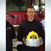 L'ancien capitaine des pompiers de Brampton, James Schwalm, pose devant un camion de pompier avec son casque à la main.