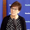 La ministre Janice Morley-Lecomte en conférence de presse devant des panneaux bleus sur lesquels le mot Manitoba est inscrit, le 2 juin 2023. 