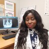 Jasmine Gitego assise devant l'écran de l'ordinateur où la radiographie de sa poitrine montre le cœur mécanique.