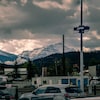 Des voitures sont stationnées à la gare de Jasper, dans la vallée de montagnes.