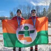 Deux jeunes athlètes posent avec leur médaille au cou en déployant le drapeau de l'Abitibi-Témiscamingue.