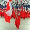 Le patineur Brian Orser porte le drapeau canadien à la cérémonie d'ouverture des JO, suivi de la délégation d'athlètes canadiens.