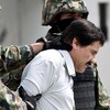 Deux soldats flanquent Joaquin El Chapo Guzman qui apparait en chemise blanche, la tête légèrement penchée vers le bas.