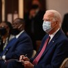 Le candidat démocrate Joe Biden portant un masque avec quelques personnes en arrière-plan.