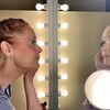 La directrice artistique de Tam ti delam, Johanne Poirier, ajustant son maquillage devant un miroir.