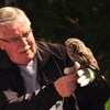 John Turner a un hibou posé sur sa main au centre de protection de la faune aviaire sur l'île de Vancouver.