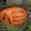 Une pierre colorée sur laquelle il est écrit : la vie de chaque enfant compte. 