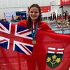 Julie Brousseau avec sa médaille et le drapeau de l'Ontario.