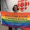 Julie Fortier tient un drapeau de la Coalition d'aide à la diversité sexuelle de l'Abitibi-Témiscamingue dans les locaux de Radio-Canada.