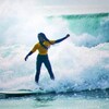La jeune surfeuse debut sur une vague.